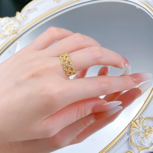 Détail d'une bague tressée en or 18 carats avec zircons portée sur une main