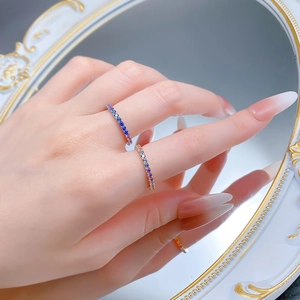 Detail of lavender gradient gemstones set in slim silver rings worn by a model