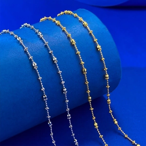 Detail of faceted gold and silver beads with star charms on elegant necklaces