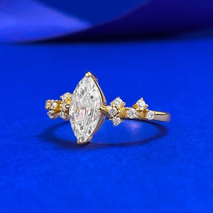 Marquise cut crystal ring in 18K gold finish with side cluster accents on navy background