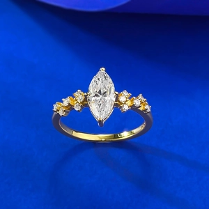 Detailed macro view of S925 silver gold ring with marquise-cut stone on blue fabric