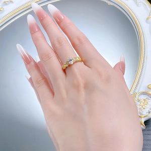 Macro shot of an oval crystal ring in gold finish with vintage pavé details on model
