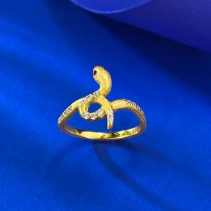 Macro shot of S925 silver snake ring with gold finish, red gem eyes and pavé details