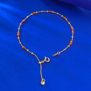Detailed macro view of S925 silver gold bracelet with garnet beads and heart pendant