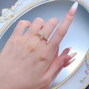 Detailed view of marquise cut solitaire ring with gold plating on model finger