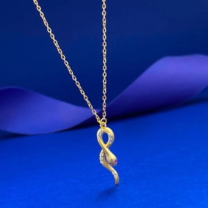 Détail du pendentif serpent doré orné de cristaux et d'une pierre précieuse rouge
