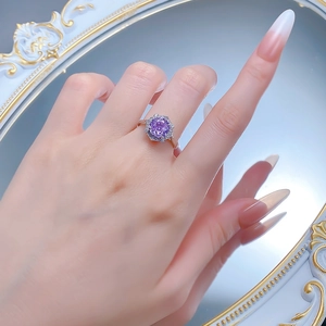 Detail of flower shaped S925 silver ring with purple round gemstone on model hand