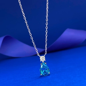 Macro d'un collier en argent S925 avec pendentif goutte bleu poire sur ruban de soie