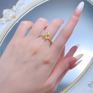 Macro detail of a gold snake ring featuring crystal pavé scales and small red gem eyes