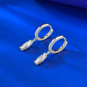 Détail de boucles d'oreilles en argent S925 avec zircons marquise sur fond bleu