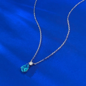 Vue détaillée du collier pendentif goutte bleue avec une chaîne argentée polie