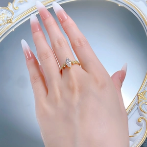 Close-up of a marquise-cut faux diamond ring in gold plating worn on a hand