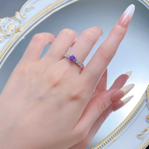 Detail of S925 silver ring with 5x7mm purple oval gemstone and side diamonds on finger