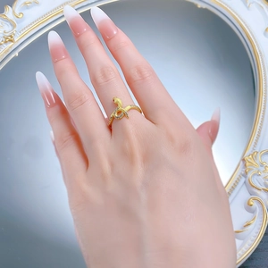 Detailed close-up of golden S925 silver snake ring with white diamonds and red eyes