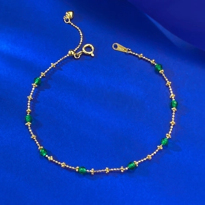 Detailed close-up of S925 sterling silver gold beaded bracelet with green beads and heart charm