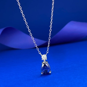 Gros plan du pendentif poire bleu saphir sur une chaîne fine en argent sterling S925