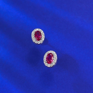 Orecchini a perno con rubino rosso sangue di piccione e halo di diamanti su seta blu