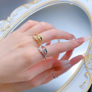 Detailed view of snake-shaped open rings in gold and silver finish with zircon accents