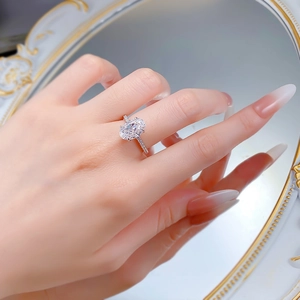 Detail of 4.5 carat oval cut ice flower silver ring with pavé diamonds on woman hand