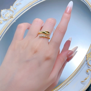 Detail of snake ring with three sparkling white zircons on a gold-plated snakehead design