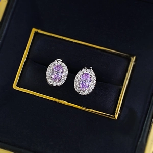Elegant lavender oval-cut earrings with halo diamonds in a navy blue jewelry box