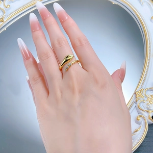 Detail of gold snake-style open ring with sparkling white zircon inlays on model hand