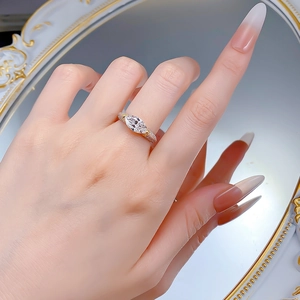 Gros plan d'une bague en argent 925 avec pierre marquise et détails plaqués or bicolores