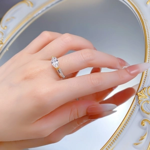 Gros plan détaillé d'une bague marquise dorée sur la main près d'un miroir doré