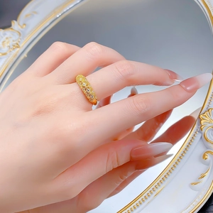Gros plan d'une bague dorée à motif losanges sertie de cristaux sur fond miroir