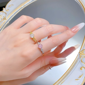 Detailed view of rose-themed rings with gold and silver bands and sparkling center stones