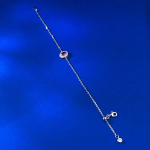 Macro detail of silver adjustable chain with lobster clasp and red oval gemstone pendant