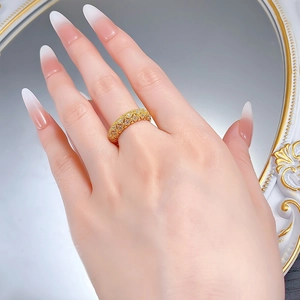Macro d'une bague dorée texturée avec pavage et motif vintage sur le doigt