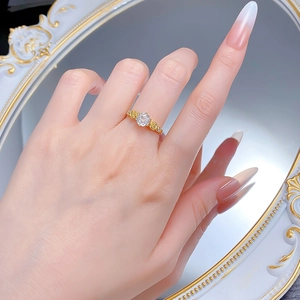 Detail of gold rose ring with a brilliant round diamond simulant and floral accents