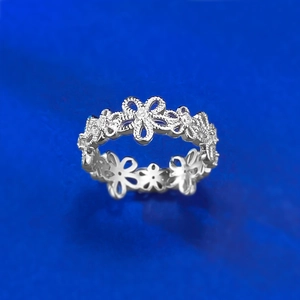 Macro shot of S925 silver lace flower ring with zircon inlays and hollow petal design