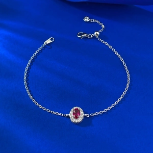 Elegant S925 silver bracelet with oval red gemstone halo on dark blue satin background