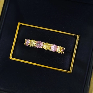 Bague éternité dorée sertie de pierres roses et jaunes alternées à taille ronde