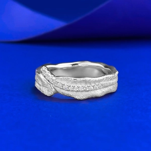 Macro shot of silver feather ring showing brushed texture and tiny diamond inlay details