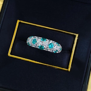 Sparkling S925 sterling silver ring with blue-green and white stones in a blue velvet box