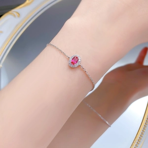 Detail of S925 silver bracelet with oval red gemstone and white zircon halo setting