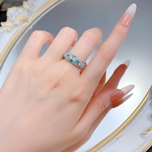 Close-up of S925 silver ring with half-band pavé set blue and white stones