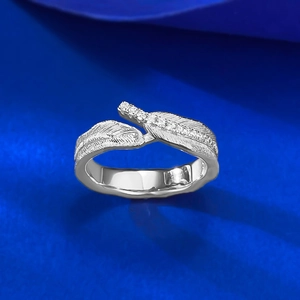 Macro shot of silver feather ring with delicate texture and inlaid white zircon details