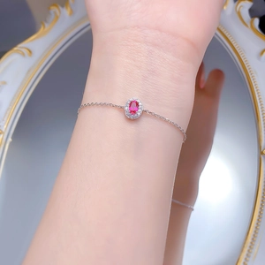 Detail of S925 silver halo bracelet with oval pink gemstone worn on woman's wrist