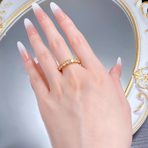 Vue détaillée d'une bague d'éternité dorée sertie de gemmes roses et jaunes alternées