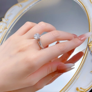 Close-up of a 2.5 carat S925 sterling silver solitaire ring on a finger with mirror reflection