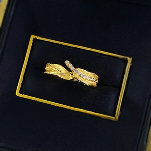 Macro view of gold feather ring with Italian brushed texture and sparkling zircon inlay