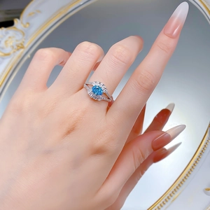 Close-up of S925 silver ring with oval aquamarine stone and micro-pave diamonds on finger