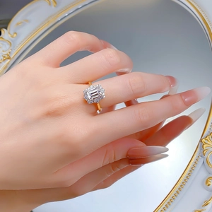 Close-up of S925 silver gold-plated ring with emerald-cut white cubic zirconia on finger