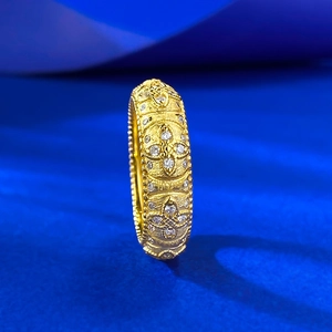 Detail of vintage gold lantern ring featuring brushed texture and inset diamonds
