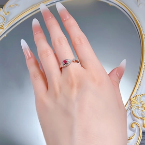 Detail of luxury S925 silver snake ring with red gemstone worn on a model finger