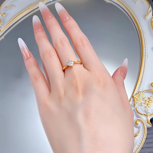 Close-up of a minimalist gold ring with a princess-cut square zircon on a woman's finger